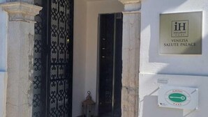 Una entrada con un arco de piedra, una reja metálica y una placa que dice "iH Exclusive Venezia Salute Palace".