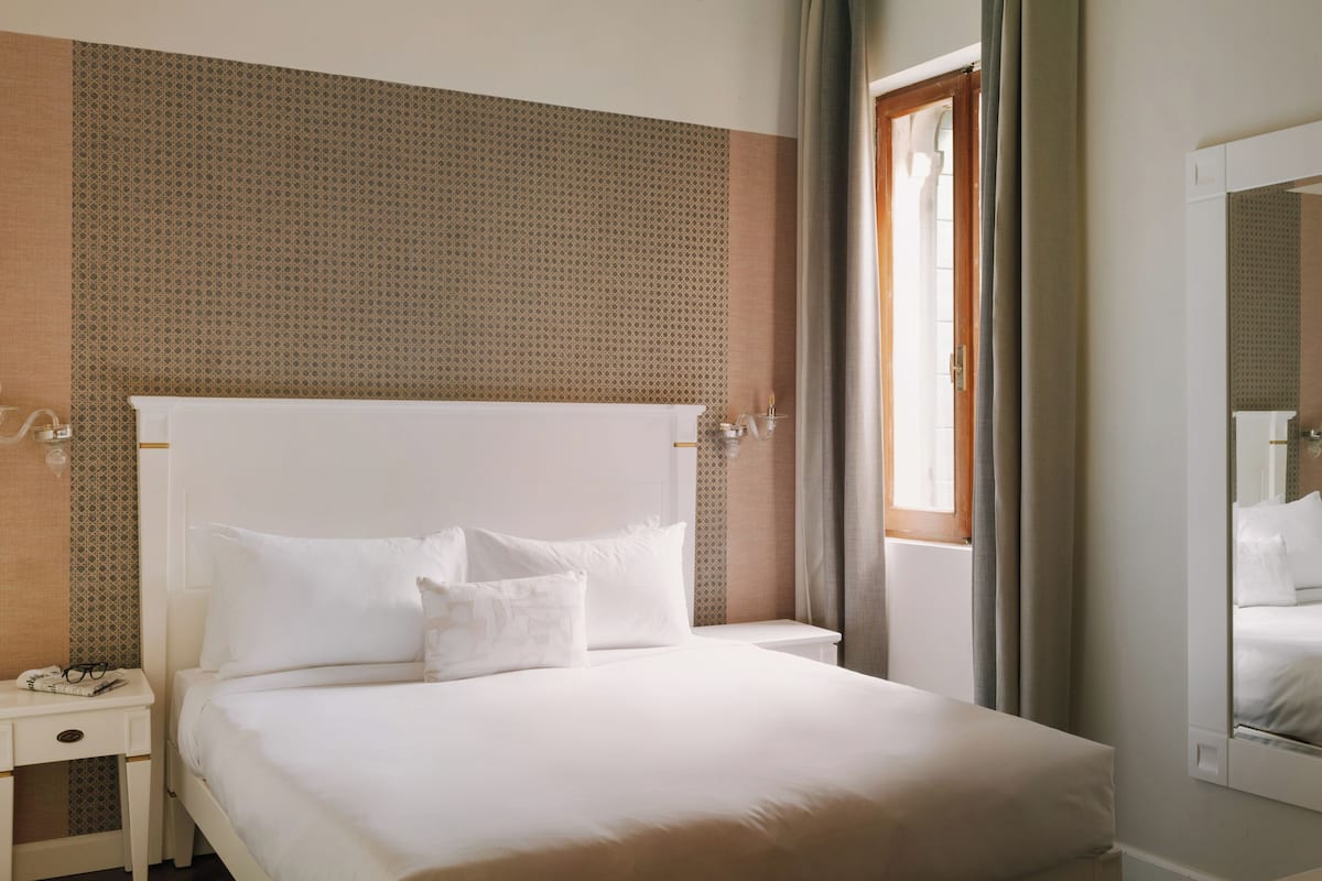 En väl bäddad säng med vita sängkläder i ett hotellrum.