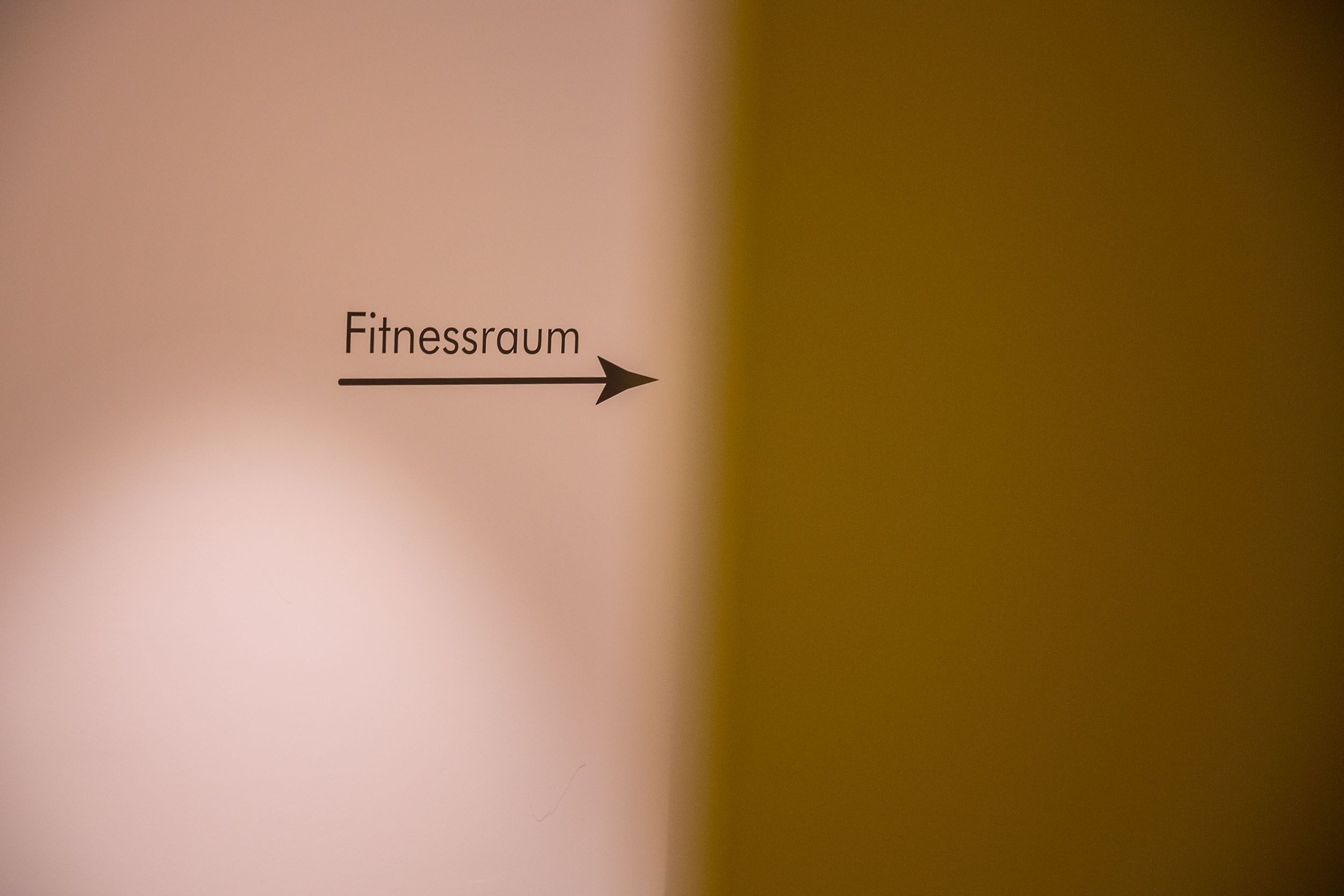 A sign indicating the direction to the fitness room.