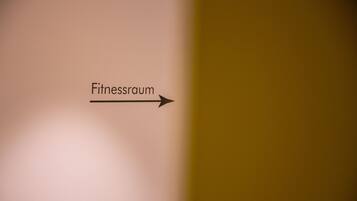 A sign indicating the direction to the fitness room.