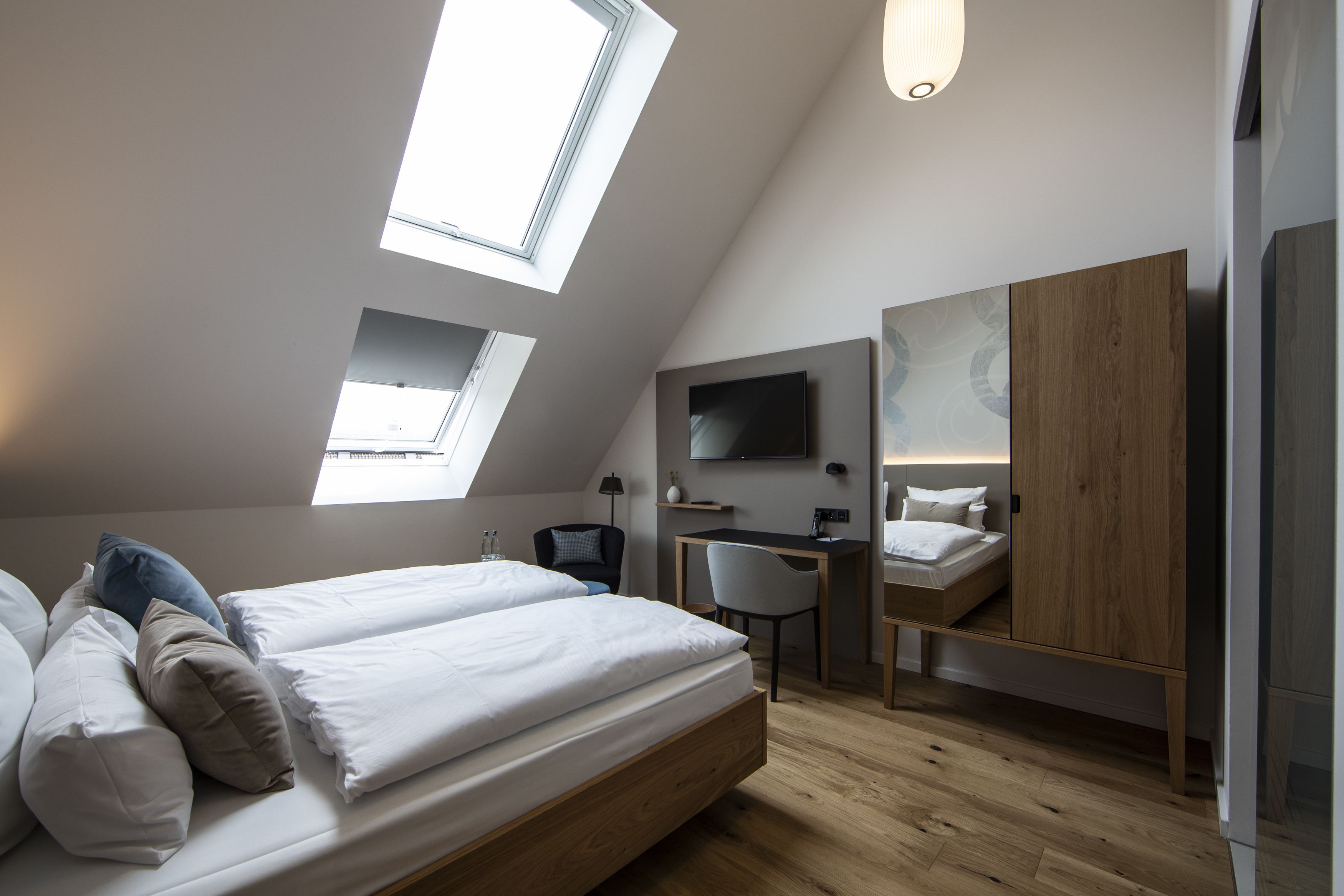Un dormitorio moderno con tragaluz, un escritorio y una cama.
