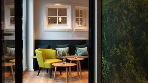 Un intérieur moderne avec un plancher en bois, un canapé jaune et une grande fenêtre.