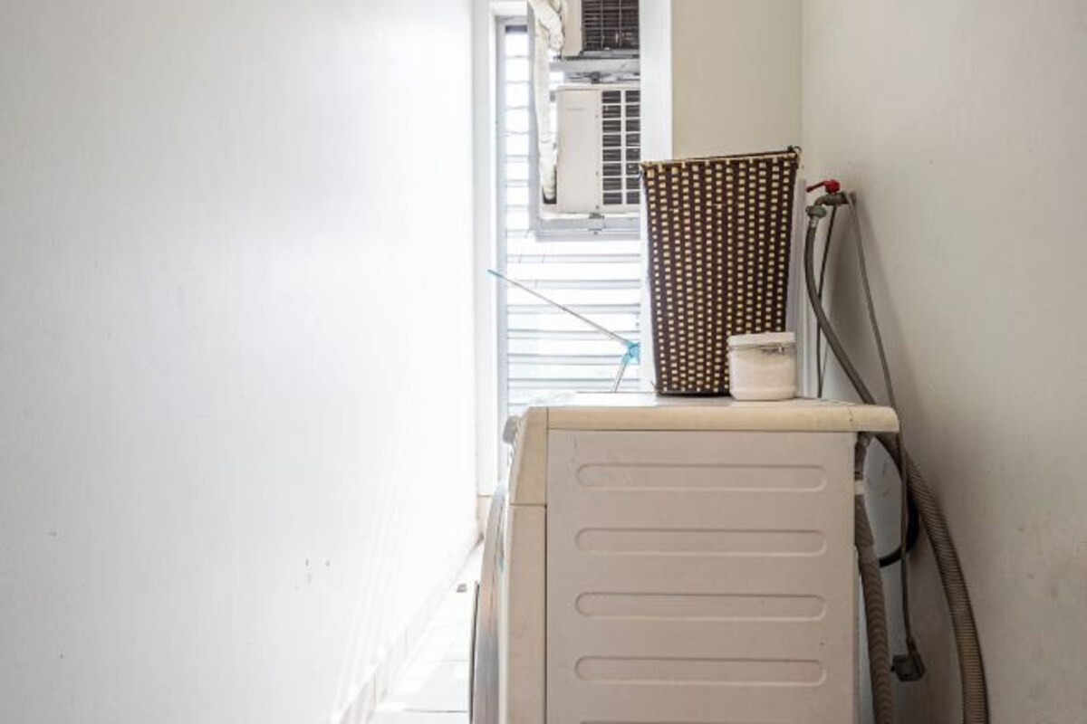 A room with a radiator, a window with blinds, and a towel rack.