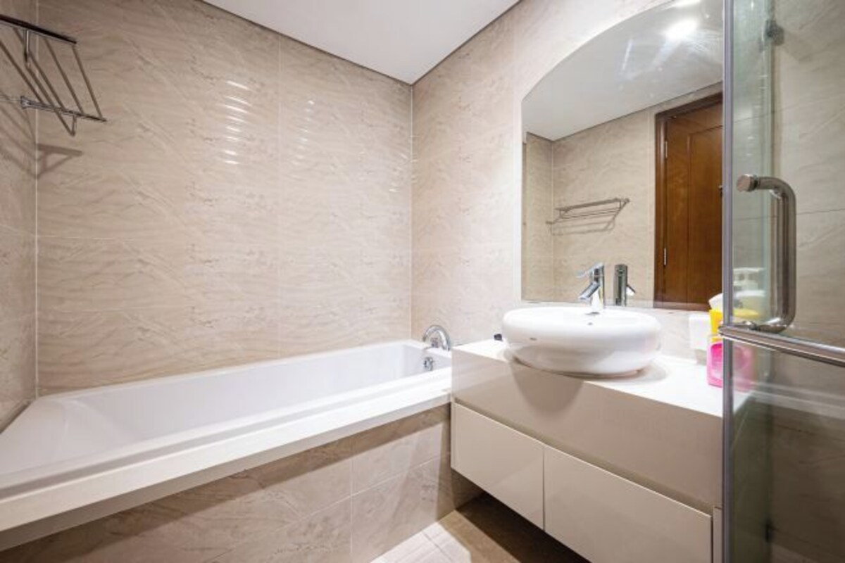 Un baño moderno con una bañera independiente, un lavabo blanco y un box de ducha de vidrio.