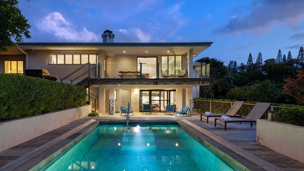 Une maison moderne dotée d’une piscine, d’une terrasse et d’un espace patio.