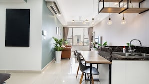 A modern kitchen with a dining area, large windows, and a view of the city.