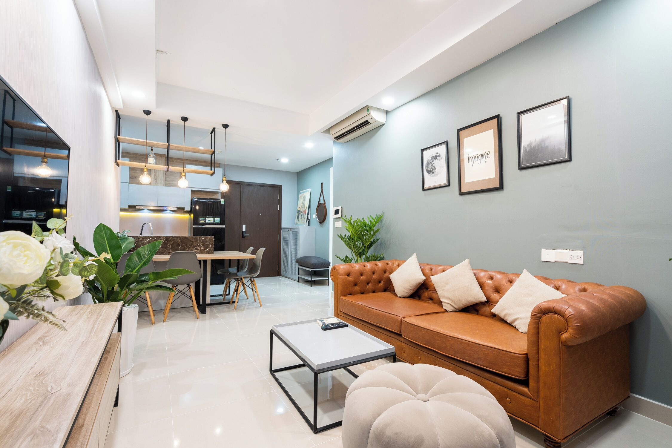 A modern living room with a leather sofa, a coffee table, and a dining area with a table and chairs.