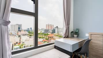 Escritorio, cortinas blackout y tabla de planchar con plancha