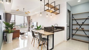 A modern kitchen with a dining area, large windows, and a city view.