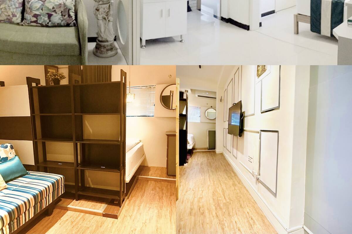 A hotel room with a bed, bedside table, and a view of the hallway.