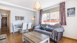 Ein modernes Wohnzimmer mit einer Couch, einem Couchtisch und einem Essbereich mit Stühlen.