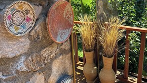 Woven baskets on a stone wall, a wooden railing, and two potted plants. - Faralya Misafir Evi (Fethiye)