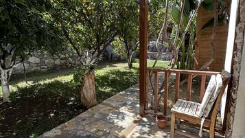 Un patio empedrado con un banco de madera y una maceta colgante.