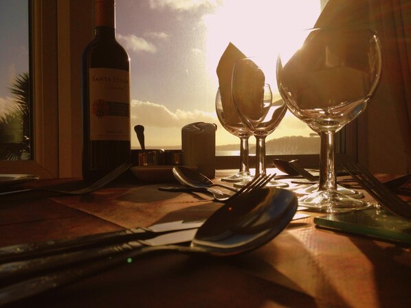 A table set for two with wine glasses, a bottle of wine, and cutlery. - Membly Hall Hotel (Falmouth)