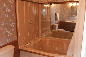 Un baño con bañera acristalada, inodoro y lavabo con espejo.