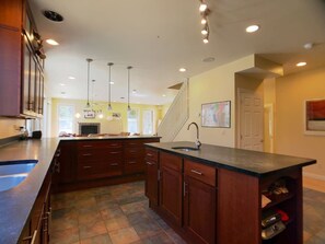 A kitchen with a central island, wooden cabinets, and pendant lighting. - Ilam House - Secluded, Ping-Pong, Gas Fireplace (Davis)