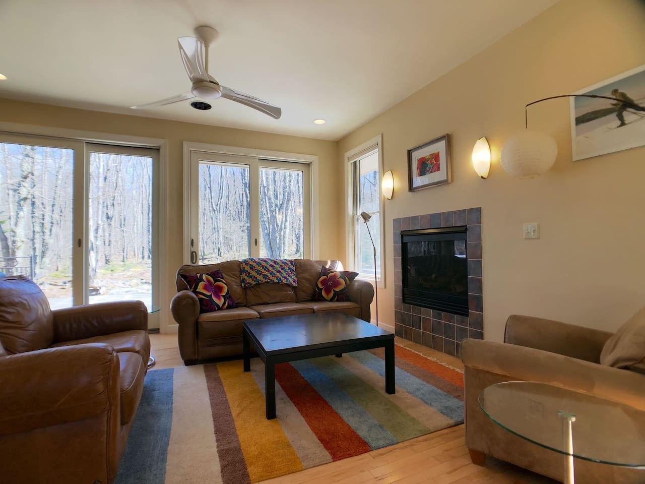 A living room with a sofa, armchairs, a coffee table, a fireplace, and a television.
