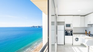 A modern kitchen with a view of the beach.