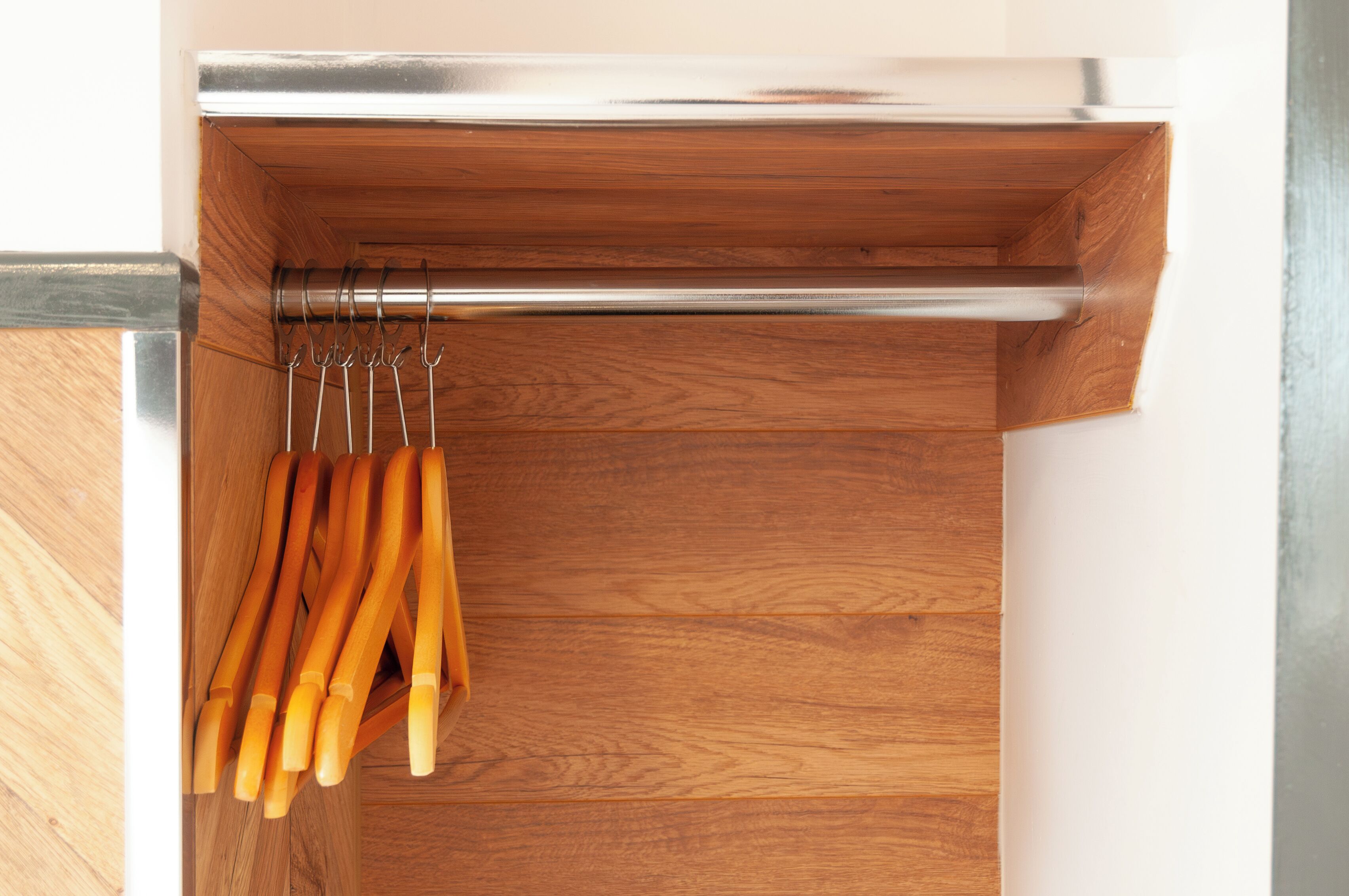 A wooden cabinet with a metal handle and a metal rod.