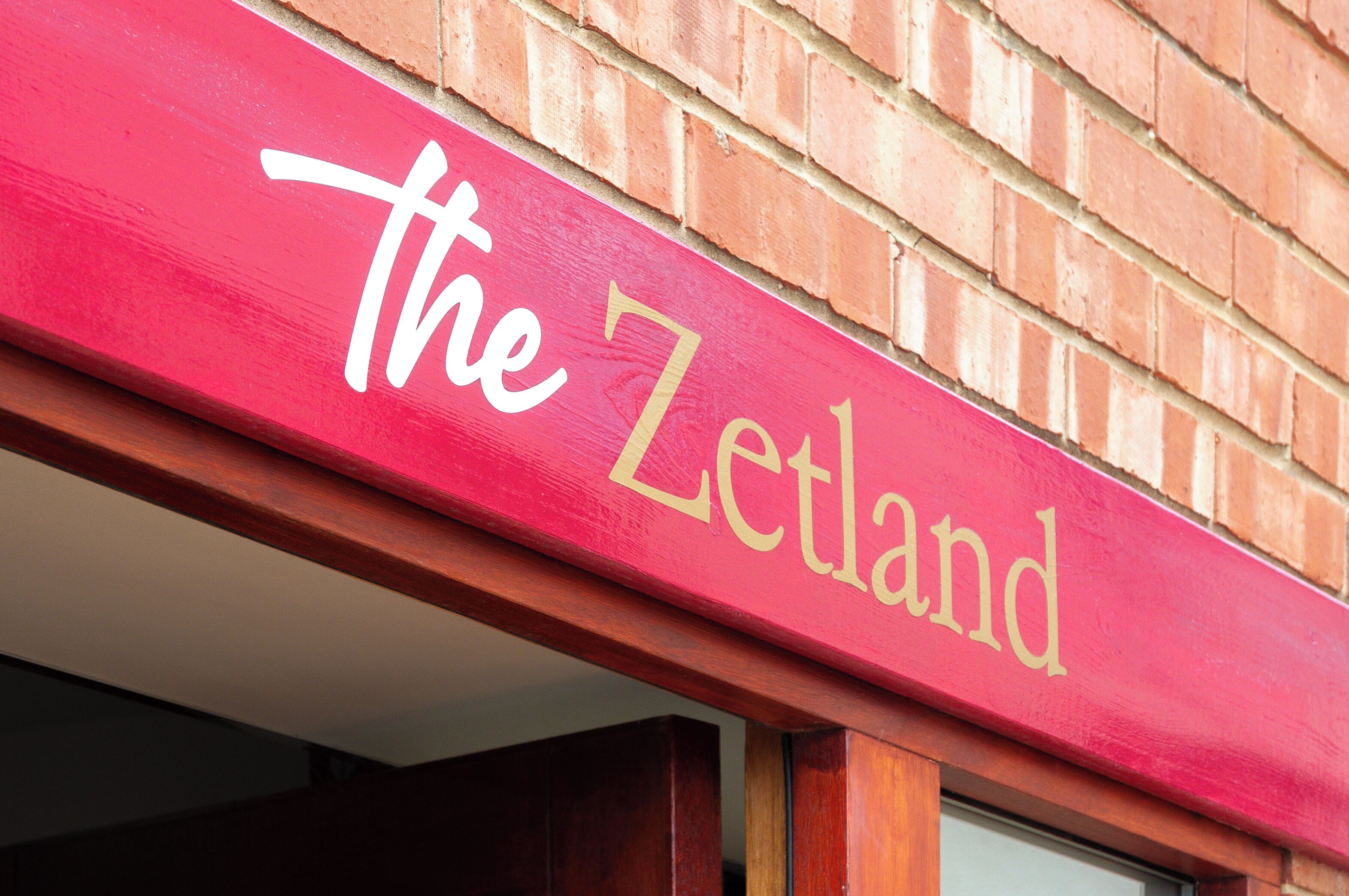 A red sign with "the Zetland" written in white.
