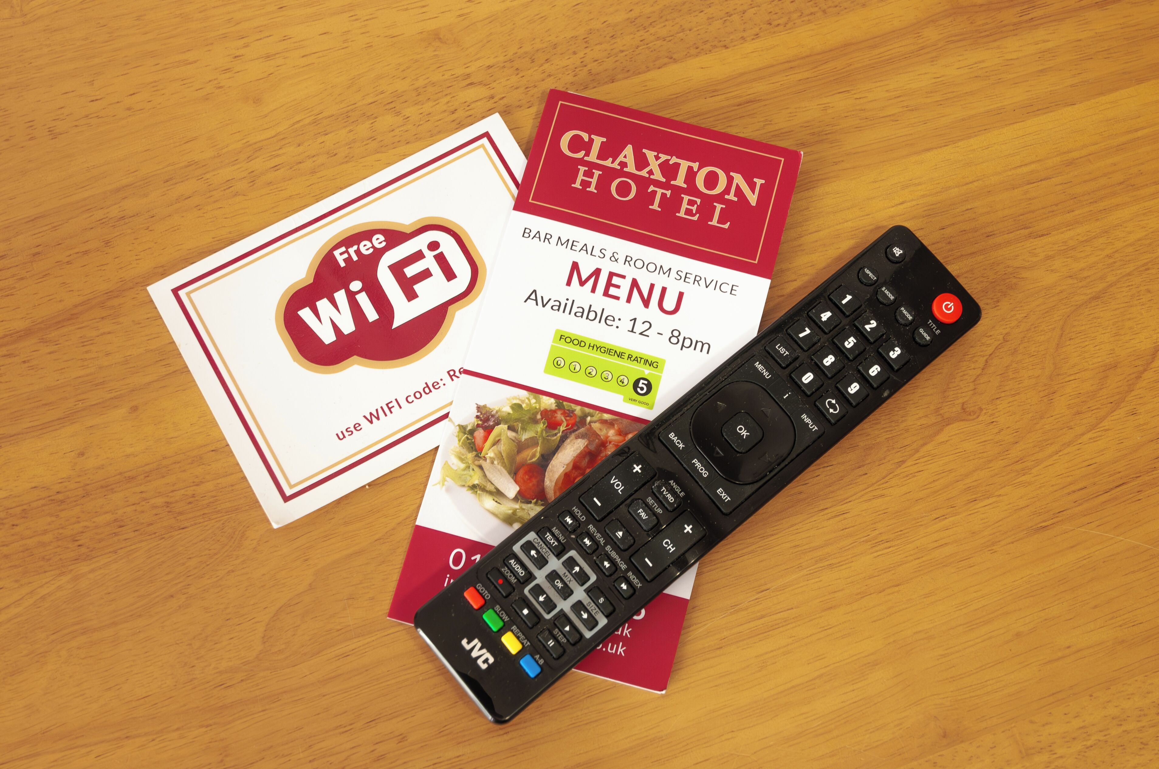 A remote control, a Wi-Fi card, and a menu card for the Clayton Hotel.