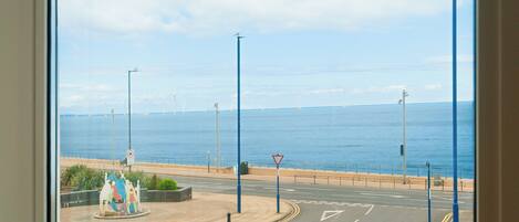 A coastal road with a roundabout and a view of the sea.