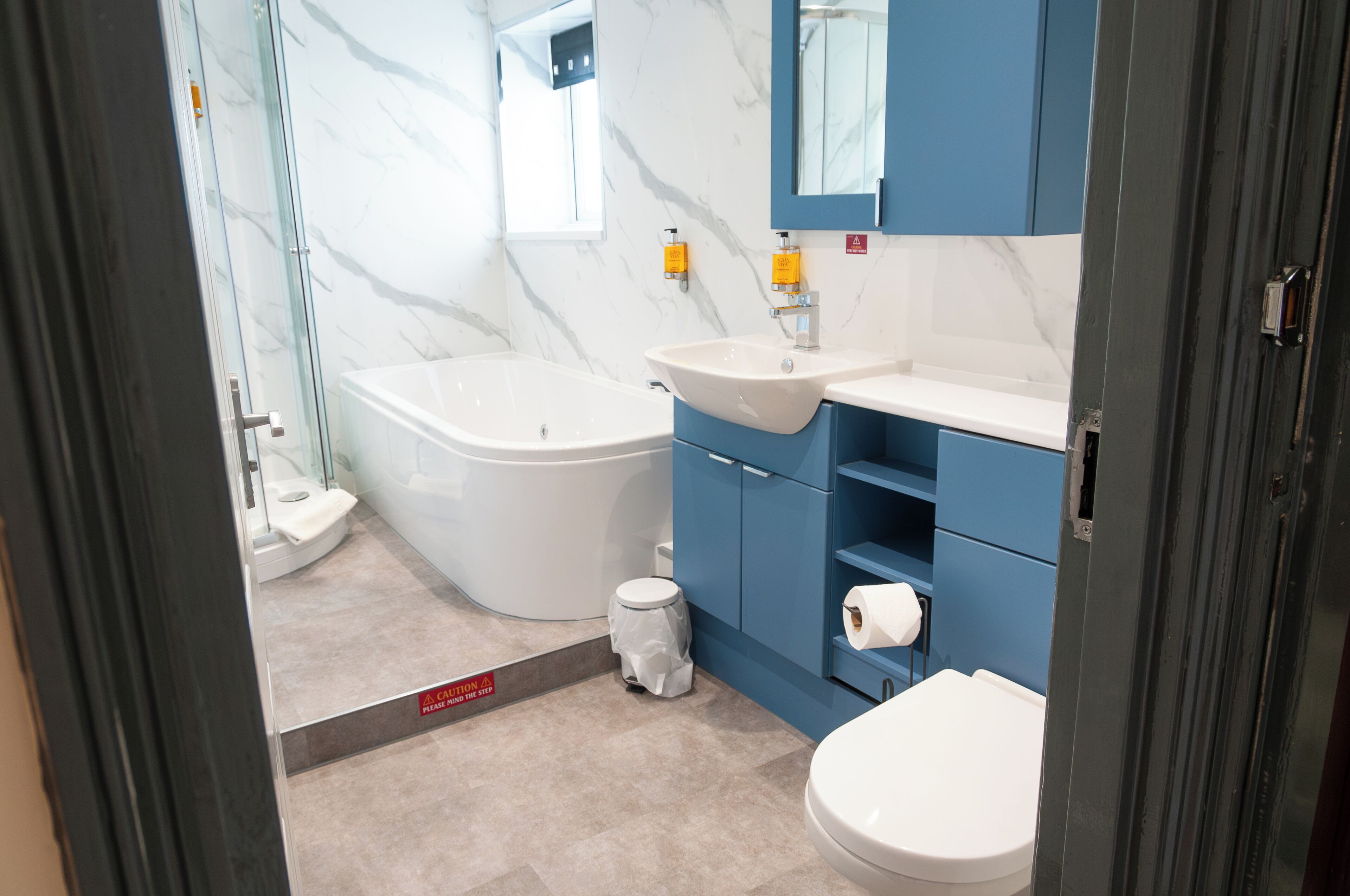 Een moderne badkamer met een bad, wastafel en toilet.