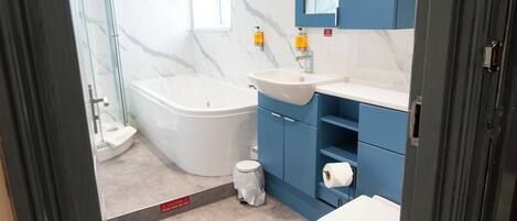 Een moderne badkamer met een bad, wastafel en toilet.