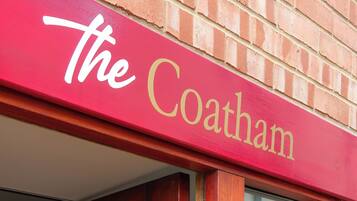A red awning with the words "The Coatham" in gold lettering.
