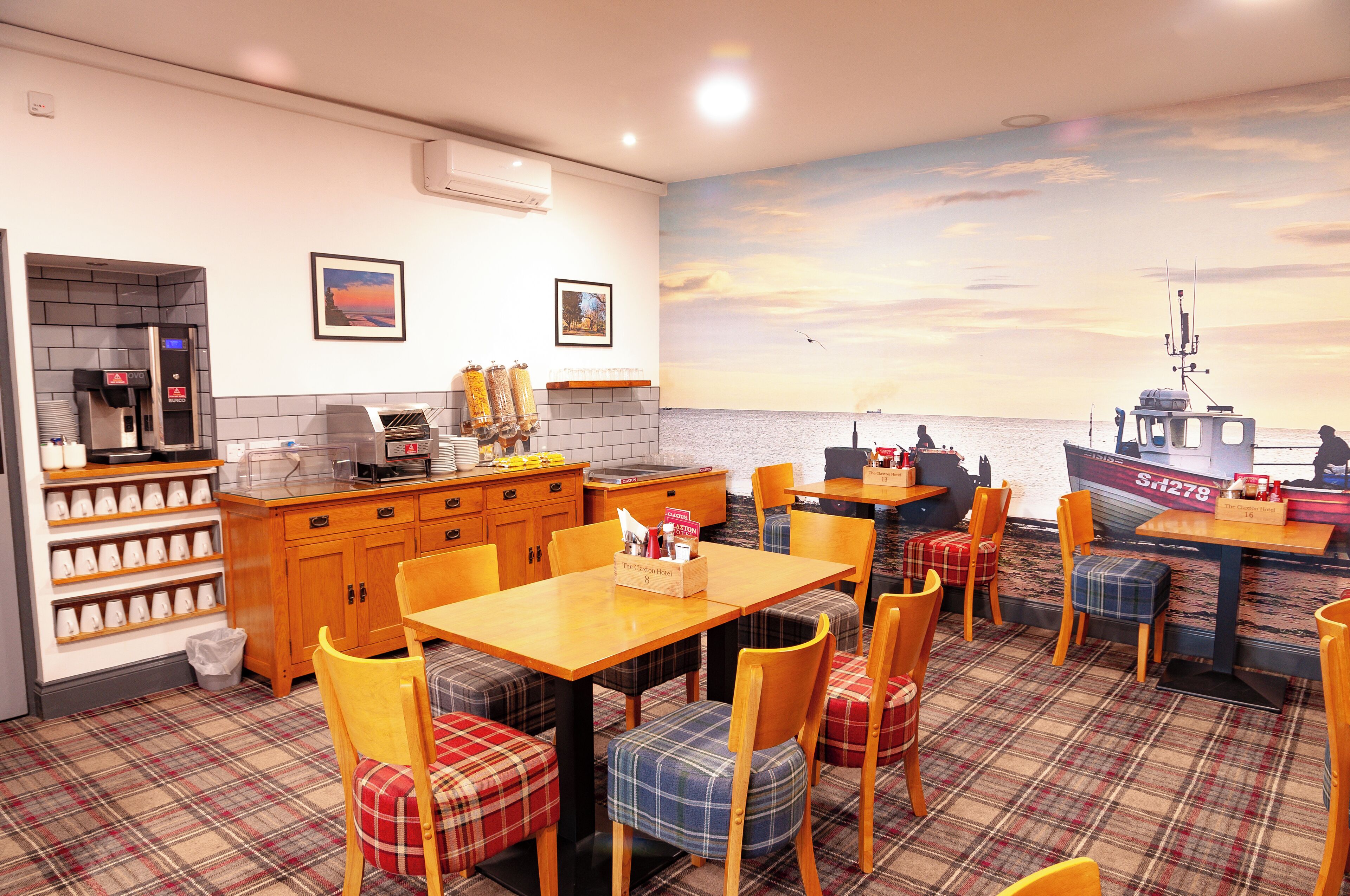 A restaurant with a nautical-themed mural, wooden furniture, and a view of the sea.