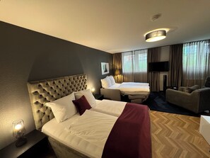 A hotel room with two beds, a sofa, a TV, and a lamp. - V Business Apartments Stuttgart Magstadt (Magstadt)