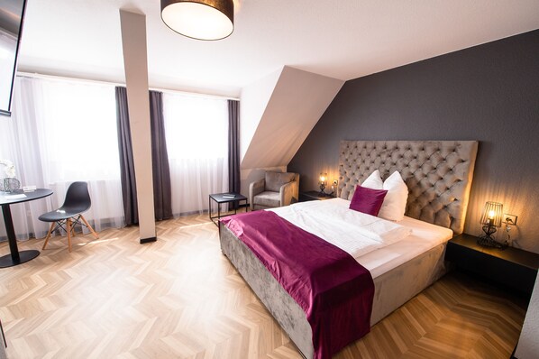 A modern hotel room with a large bed, a desk, and a chair. - V Business Apartments Stuttgart Magstadt (Magstadt)