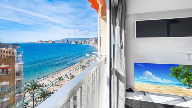 Un balcón con vista a la playa y al paisaje urbano.
