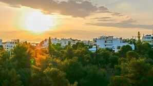 A coastal town with modern buildings, a clear view of the sea, and dense greenery in the foreground. - Voula- Archer Amazing Sea View Apartment (Vari-Voula-Vouliagmeni)