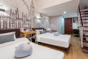 Une chambre d’hôtel avec deux lits, un bureau avec une chaise, une fresque murale représentant des bâtiments de la ville et un escalier.