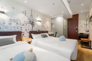 Une chambre d’hôtel avec deux lits, un bureau, une chaise et un mur décoré d’une fresque représentant un paysage urbain.