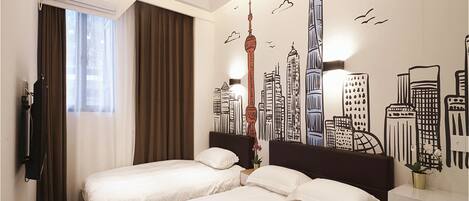 A hotel room with two beds, a cityscape mural on the wall, a modern chandelier, and a window with curtains.