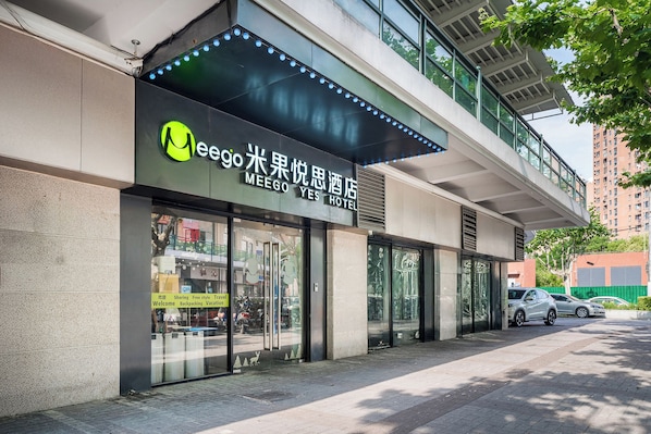 Un hôtel moderne doté d’une façade en verre et d’une enseigne en anglais et en chinois.
