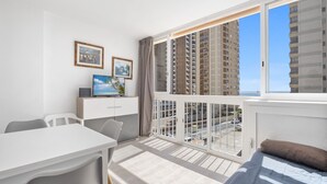 A modern hotel room with a balcony, a dining area, and a bed with a view of the cityscape. - Bacana 3-3 (Benidorm)