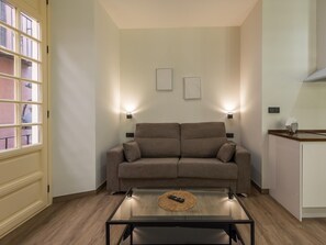 A living room with a sofa, a coffee table, and two wall-mounted lights. - Chinitas 17 IIi - iloftmalaga (Málaga)