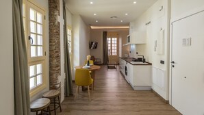 A narrow hallway with a dining area, kitchen, and a door leading to another room. - Chinitas 17 IIi - iloftmalaga (Málaga)
