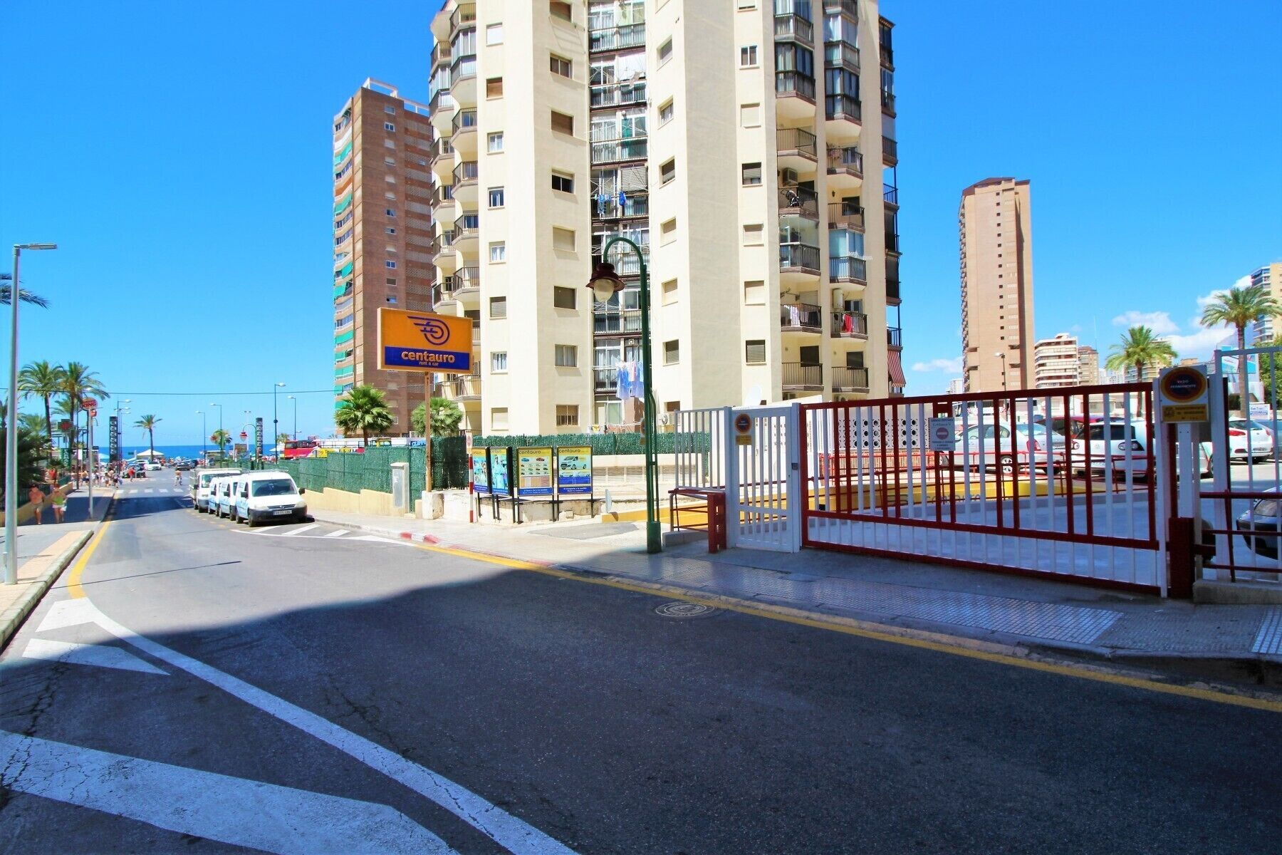 Un immeuble à plusieurs étages doté de balcons, d’une enseigne « Centauro » et d’une entrée sécurisée par un portail.