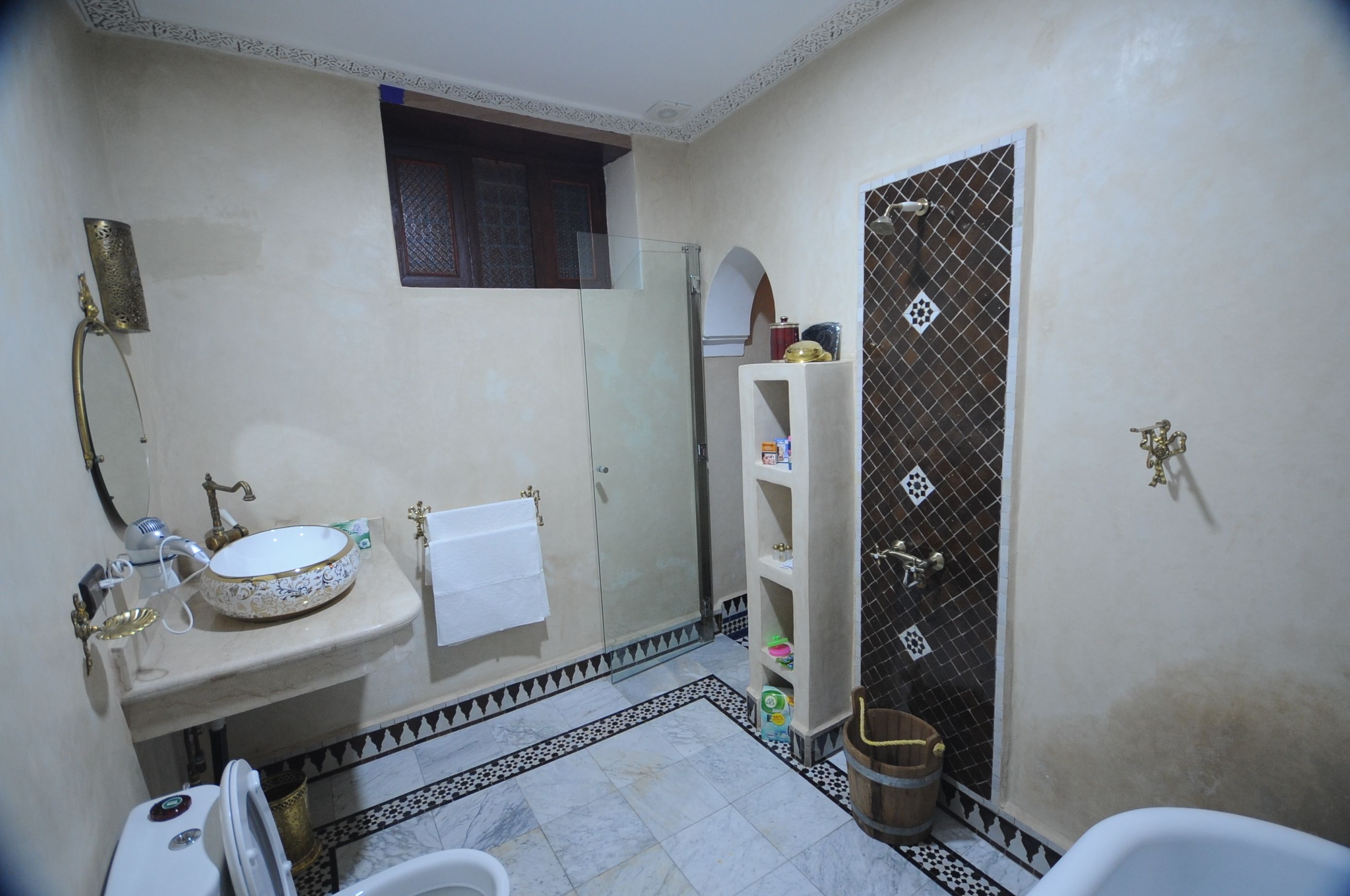 Een badkamer met een wastafel, spiegel en douche.