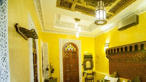 Une chambre traditionnelle avec un lit, une porte et un lustre.