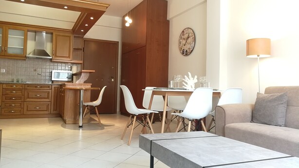 A modern kitchen with wooden cabinets, a microwave, and a dining area with a table and chairs.
