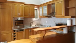 A modern kitchen with wooden cabinets, stainless steel appliances, and a window providing natural light.