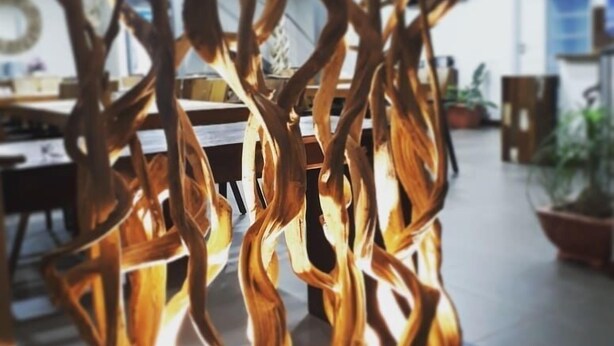 A modern interior with abstract wooden sculptures, a dining area, and potted plants. - Hotel Karem Bay (Koumac)
