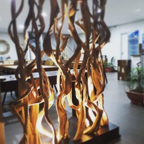 A modern interior with abstract wooden sculptures, a dining area, and potted plants. - Hotel Karem Bay (Koumac)
