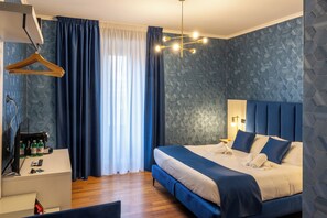 Habitación Deluxe, varias camas | Edredones de plumas, caja fuerte, decoración individual y escritorio