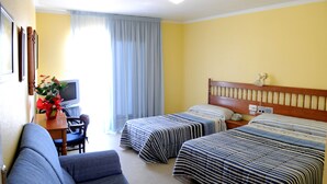 A hotel room with two beds, a desk with a TV, and a chair. - Hotel Plaça Vella (Sant Carles de la Rapita)